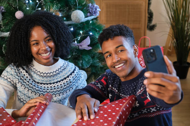 istock Couple taking selfie wrapping Christmas presents under tree 2180261578