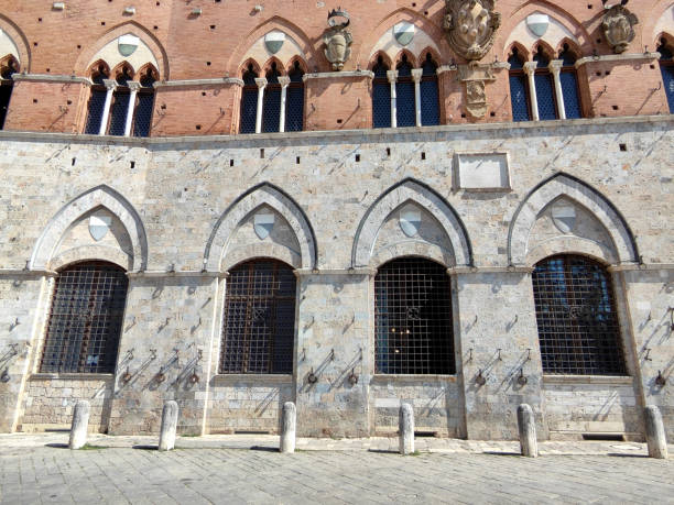 Facade of the Palazzo Pubblico, surrounding the shell-shaped Piazza del Campo, the main square of the historic center of Siena, Tuscany,