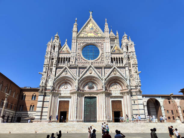 People walking at Siena Cathedral, a medieval church in Siena, Italy. It is renowned worldwide for its beauty and architectural integrity.