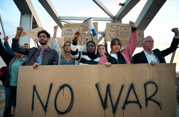 istock Crowds of diverse people protesting in silence against war in world with serious expression 2180263357