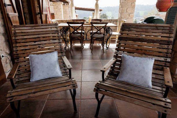 Beautiful sunny patio with dining table, chairs and BBQ in summer house during the day without people