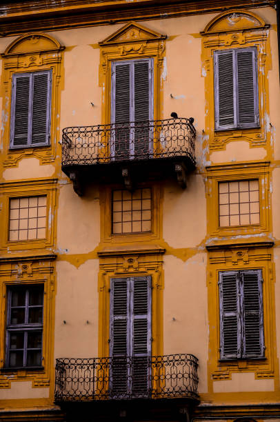 istock A yellow building with a balcony and a bird on it 2180264463