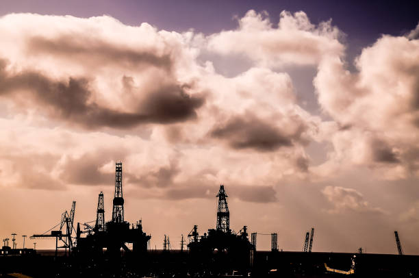 Drone view captures the Permian Basin at sunset, revealing the sprawling landscape of fracking drilling and oil rigs that stretch out towards the horizon