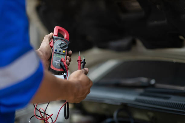 istock An auto mechanic is inspecting the electrical system and battery inside the car. 2180264828