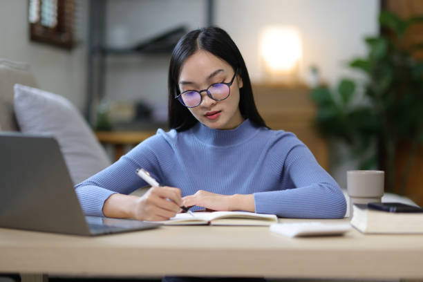 istock Serious young Asian woman is bored from working at home. 2180265123