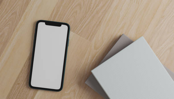 istock top view smartphone mockup blank screen on wooden table. 3d illustation rendering. 2180269038