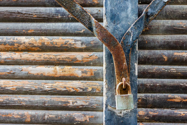 Old Rusty Lock on Weathered Wooden Log Cabin Wall