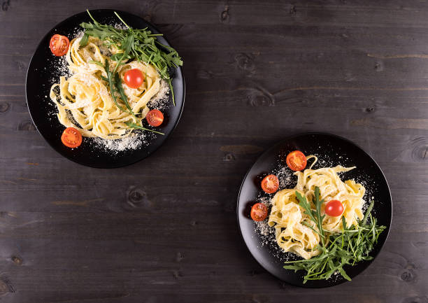 istock Top view on black plates with pasta 2180275066