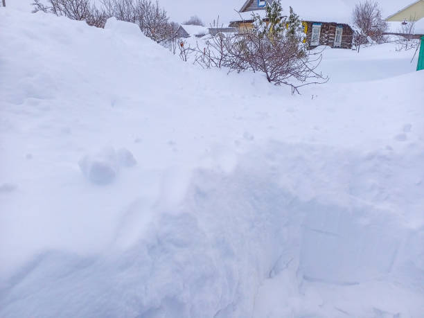istock Consequences of heavy abnormal snowfall during extreme snowfall with high snowdrifts that blocked access to other buildings. Need to remove large amounts of solid winter precipitation, clearing cost 2180279605
