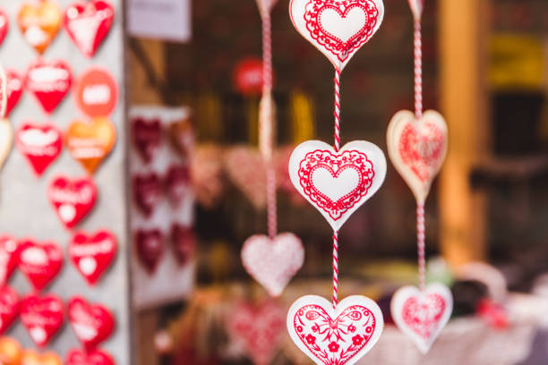 Pink hearts hanging from pink ribbons on rose background. Horizontal composition with copy space. Valentine's Day concept.