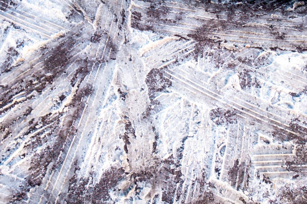 Dirty snow on the road surface, with criss-crossing tire tracks in all directions.