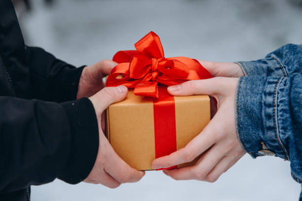 istock man presents Christmas gift to woman 2180284621