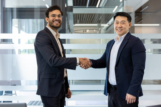 istock Professional handshake between two smiling businessmen in modern office setting signifying successful partnership or agreement 2180285651