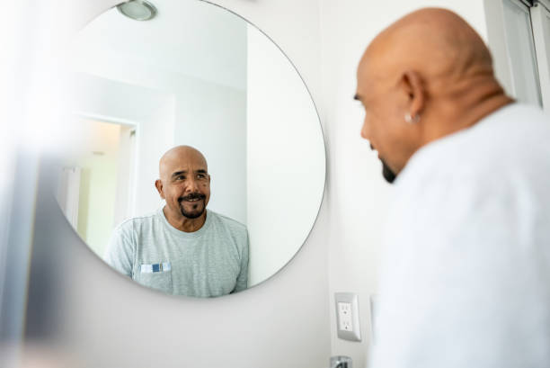istock Senior man looking in the mirror at home 2180287315