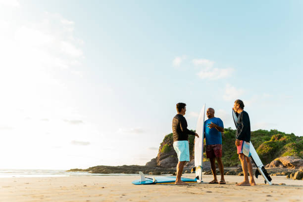 istock Surfer friends talking on the beach 2180287891