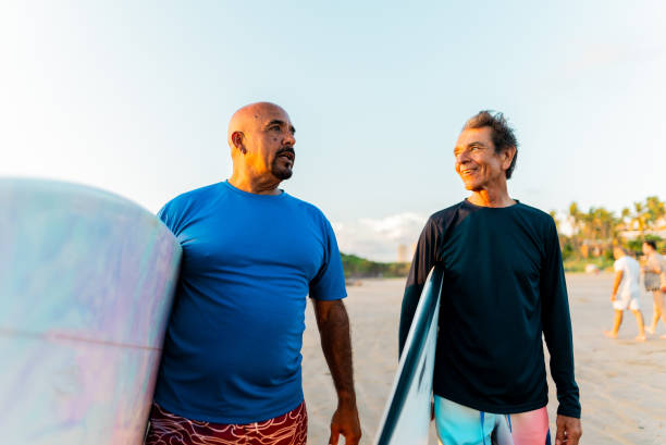 istock Senior surfer friends talking on the beach 2180287930