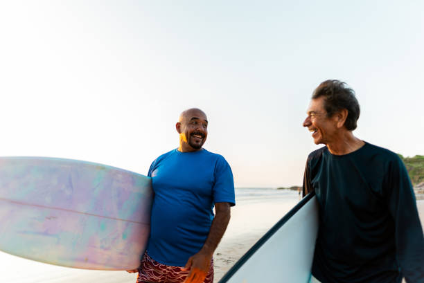 istock Senior surfer friends talking on the beach 2180287934