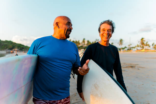 istock Senior surfer friends talking on the beach 2180287938