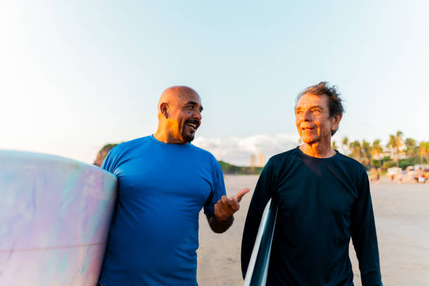 istock Senior surfer friends talking on the beach 2180287941