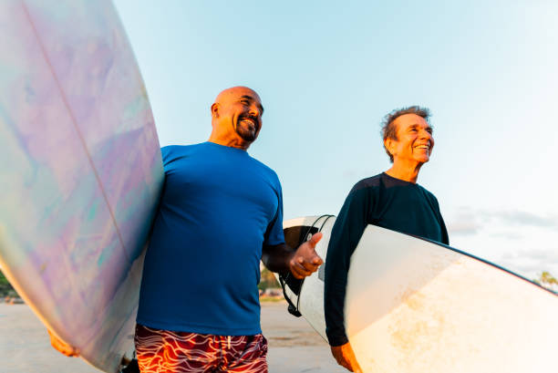 istock Senior surfer friends talking on the beach 2180287942