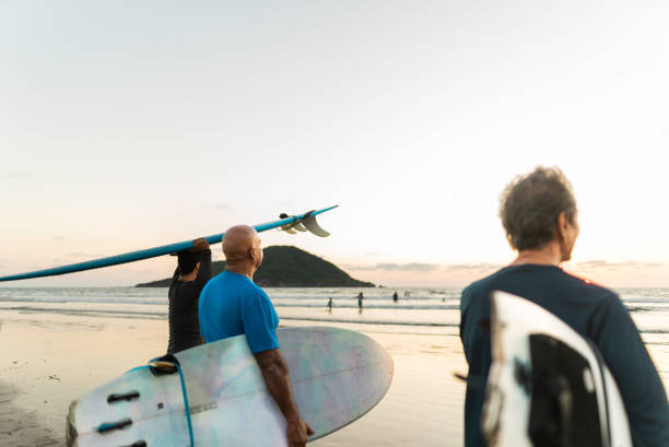 istock Surfer friends walking with surfboard on the beach 2180287971