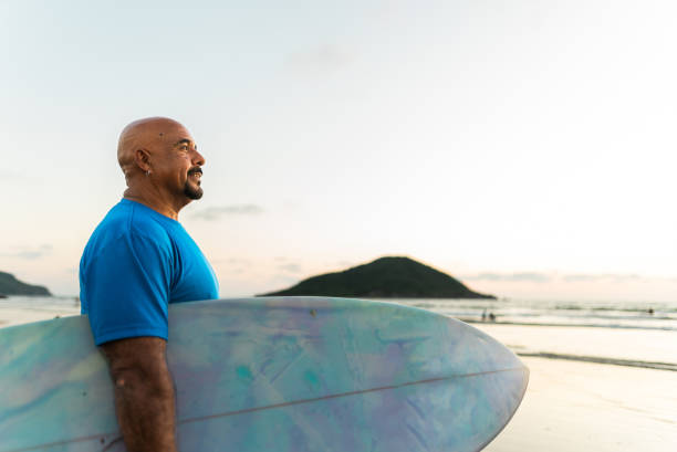 Senior surfer man contemplating on the beach