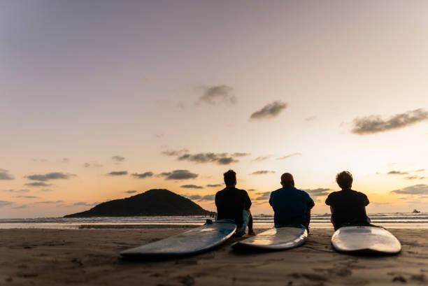 istock Surfer friends looking at view on the beach 2180288017