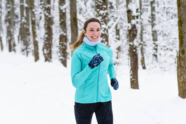 istock middle aged woman runs in winter park 2180288018