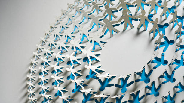 istock White and blue paper chain of human figures arranged in a spiral shape, symbolizing collaboration and unity in an interconnected world. 2180288768