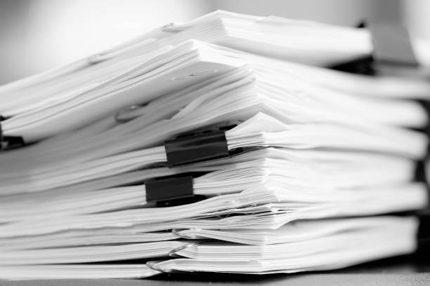 istock Pile of Papers with Binder Clips for Organizing on Desk Work to Get Done 2180290685