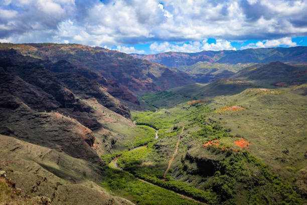 Rolling green valleys weave through dramatic cliffs, where vibrant colors and dynamic cloud formations create a breathtaking landscape in the heart of Kauai.