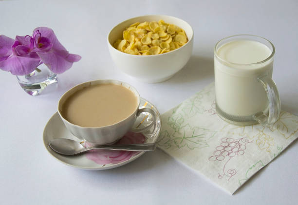 Young woman having breakfast at home and looking at the camera smiling
