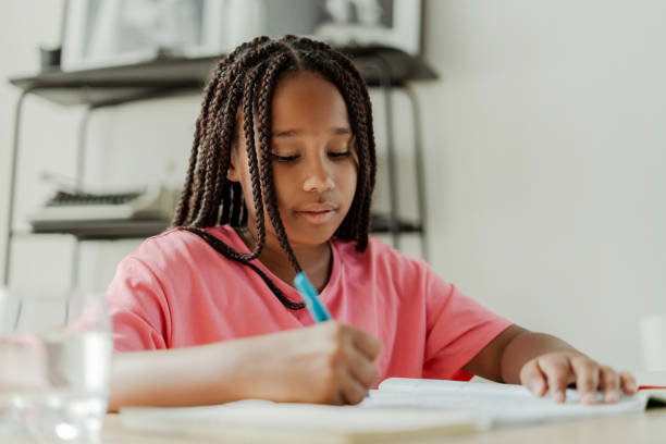 istock Young black girl doing homework concentrating on studies 2180294039