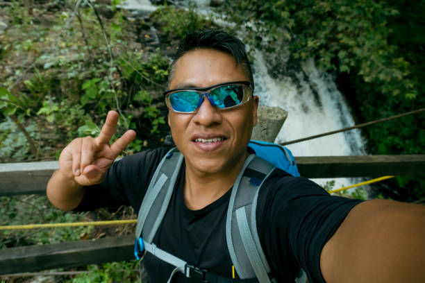 istock Selfie in Nature: Man Captures the Moment Against Breathtaking Waterfalls 2180297723