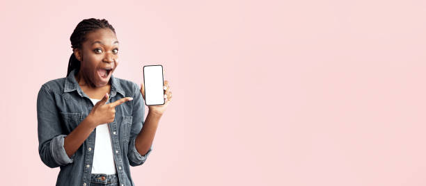 istock Excited African Lady Showing Phone Blank Screen Over Pink Background 2180300207