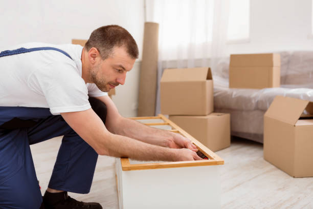 istock Repairman In Coverall Fixing And Assembling Shelf With Screwdriver Indoors 2180306200