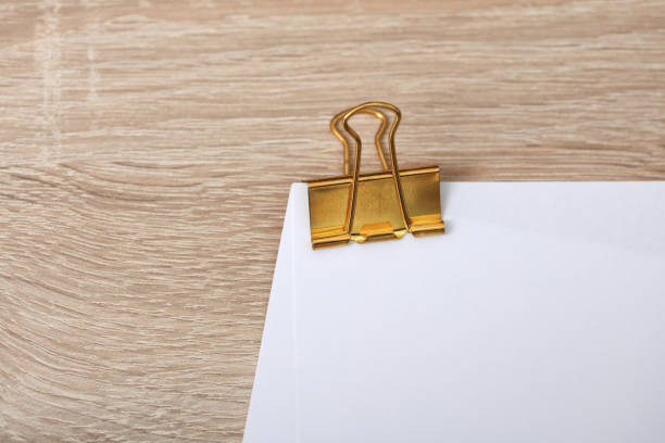 Golden binder with white empty sheet of paper on the table