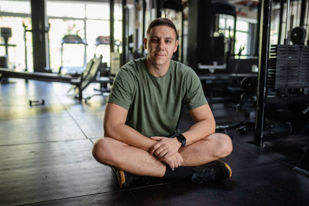 istock Man seated cross-legged on gym floor, relaxed mood 2180306938