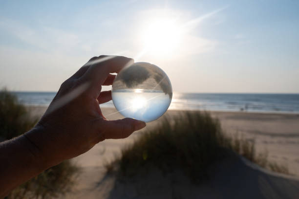 istock Beach and sea reflected in a ball in a human hand 2180307162