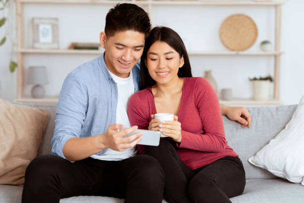 istock Korean couple resting at home, using phone 2180308021