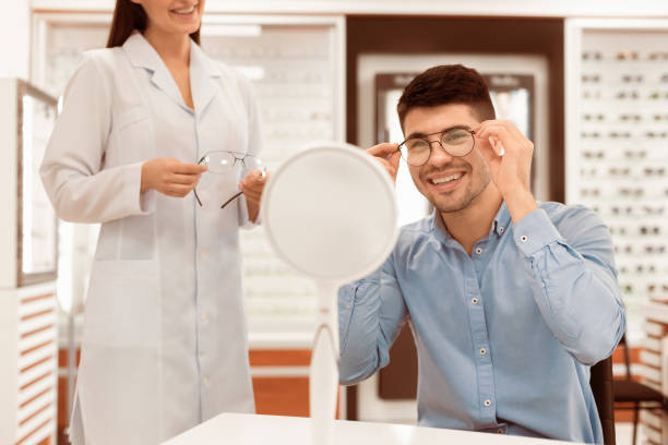 istock Optometrist helping young guy to choose correction glasses 2180309060