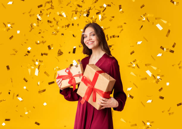 istock Beautiful Lady Standing Under Falling Confetti With Gift Boxes In Hands 2180309733