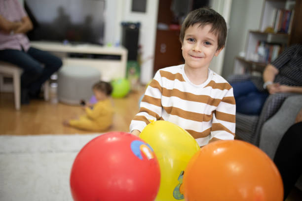 A cute eared baby crawls among bright multi-colored balls. Cute baby in the children's room. Close-up portrait