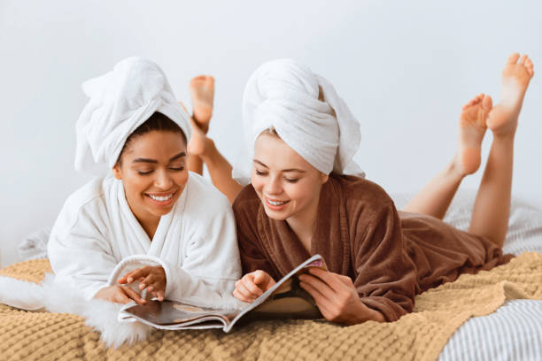 istock Carefree multiracial ladies reading magazine while having spa procedures 2180314252