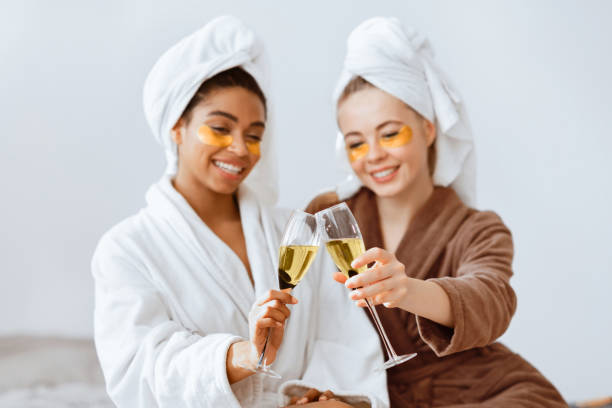 istock Relaxed girlfriends with eye patches on toasting with champagne 2180314403