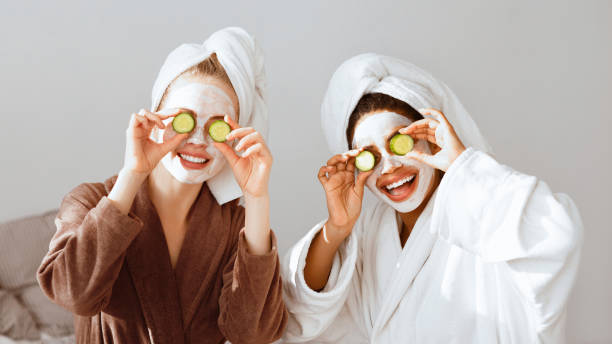 istock Girlfriends in bathrobes and face masks covering eyes with avocado 2180314432
