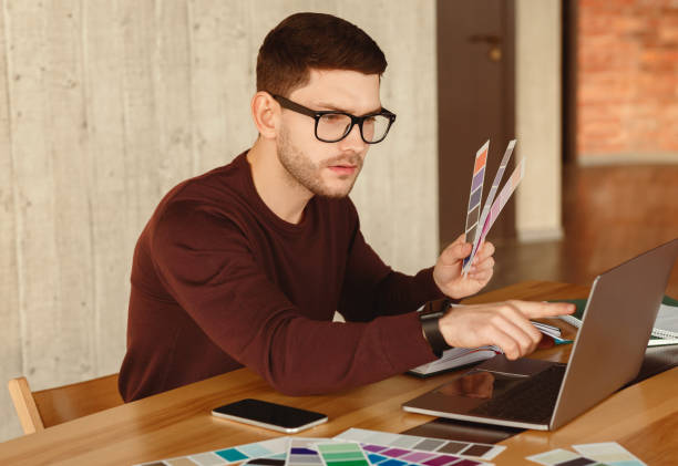 istock Designer Freelancer Working On Laptop Choosing Color Samples In Office 2180316097