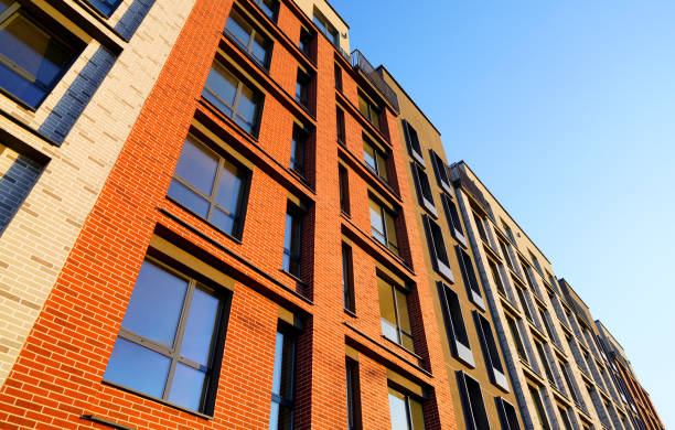 istock Brick Facade building background. Building exterior on blue sky. New condo home complex. 2180316279