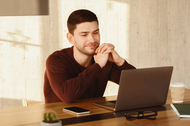 istock Smiling Man At Laptop Looking At Computer Working In Office 2180316302