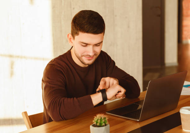 istock Office Worker At Laptop Checking Time Sitting In Office 2180316325